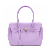 A lavender purple leather handbag with silver-tone hardware, featuring a structured rectangular body, dual top handles, a front flap with a bow detail, and a hanging clochette, photographed on a clean white background.